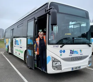 une femme pose à l'entrée d'un bus Rémi